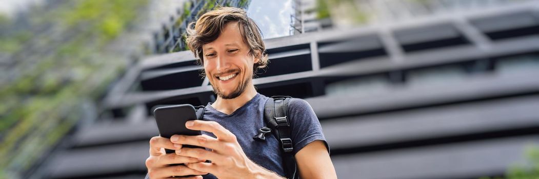 man using map app on smartphone on the background of skyscrapers. BANNER, LONG FORMAT