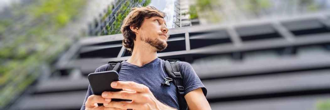 man using map app on smartphone on the background of skyscrapers. BANNER, LONG FORMAT