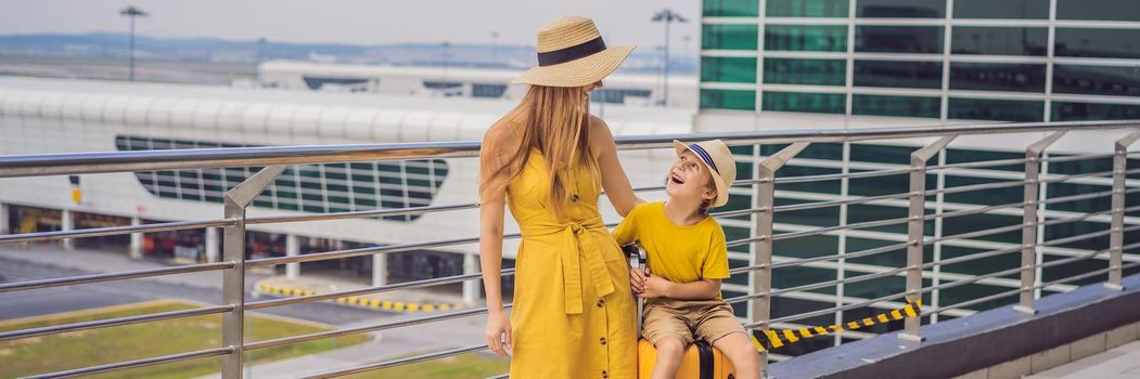 BANNER, LONG FORMAT Family at airport before flight. Mother and son waiting to board at departure gate of modern international terminal. Traveling and flying with children. Mom with kid boarding airplane. yellow family look.