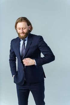 a handsome brutal bearded and long-haired man, a stylish businessman on a white background. High quality photo