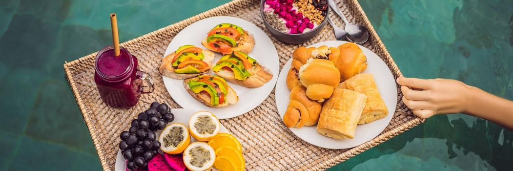 BANNER, LONG FORMAT Breakfast tray in swimming pool, floating breakfast in luxury hotel smoothies and fruit plate, smoothie bowl by the hotel pool. Exotic summer diet. Tropical beach lifestyle. Bali Trend.