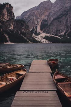 Amazing view of Lago di Braies, Pragser wildsee. Trentino Alto Adidge, Dolomites mountains, South Tyrol, Italy, Europe. Boats at the lake. Fanes-Sennes-Braies national park. brown boats