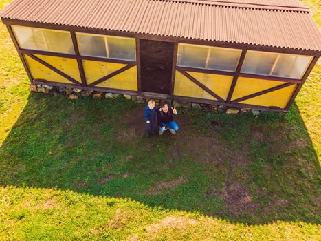 Father and son operating the drone by remote control. Young man with little boy flying drone, enjoying summer vacation.