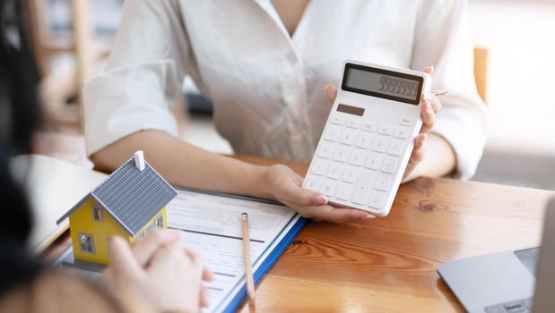 Real estate broker agent being analysis and making the decision a home estate loan to customer to signing contract documents for realty purchase, Bank employees recommend mortgage loan approval..
