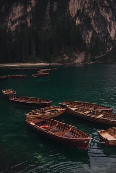 romantic place with brown wooden boats stand on the azure water on the alpine lake Lago di Braies. Dolomites, South Tyrol, Italy, Europe. italian alps.