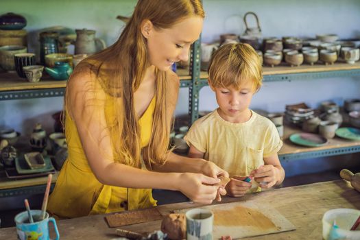 mother and son doing ceramic pot in pottery workshop.