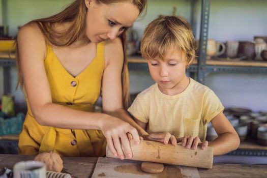 mother and son doing ceramic pot in pottery workshop.