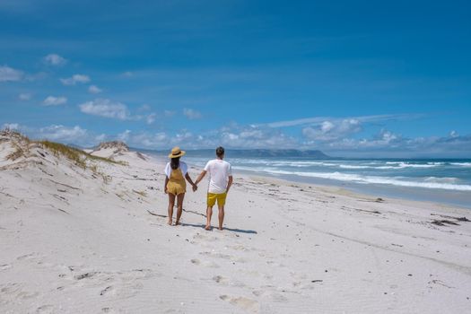 Cape Nature Walker Bay beach near Hermanus Western Cape South Africa. white beach and blue sky with clouds, sand dunes at the beach in South Africa, couple man and woman at the beach