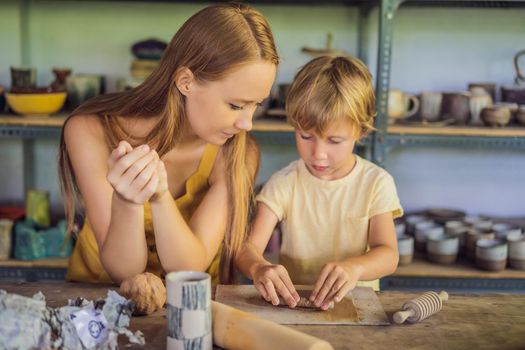 mother and son doing ceramic pot in pottery workshop.