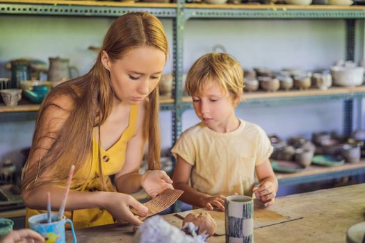 mother and son doing ceramic pot in pottery workshop.