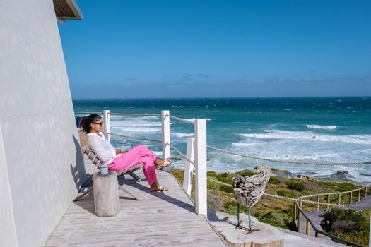 Women watching de ocean on a balcony at De Hoop Nature reserve South Africa Western Cape, white dunes at the de hoop nature reserve which is part of the garden route.