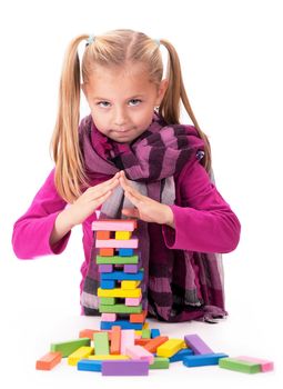 little girl playing with the wood game jenga on white background