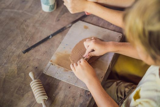 mother and son doing ceramic pot in pottery workshop.