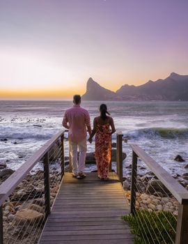 couple man and women drinking coffee during on balcony sunrise at vacation in Cape Town South Africa.