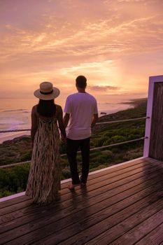 couple man and woman watching the sunset at De Hoop Nature reserve South Africa Western Cape, beach of South Africa white dunes at the de hoop nature reserve which is part of the garden route.