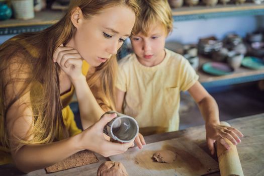 mother and son doing ceramic pot in pottery workshop.