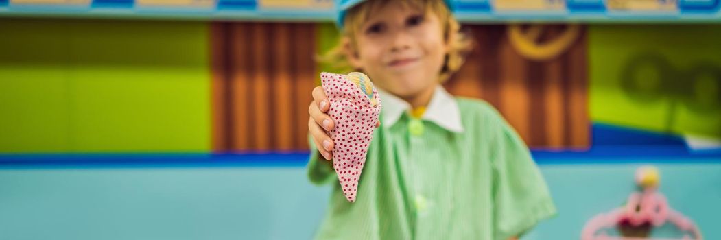 A boy plays in a toy kitchen, makes a toy ice cream. BANNER, LONG FORMAT