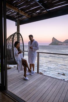 couple man and women drinking coffee during on balcony sunrise at vacation in Cape Town South Africa.