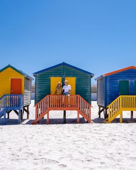 colorful beach house at Muizenberg beach Cape Town, beach huts, Muizenberg, Cape Town, False Bay, South Africa. couple man and woman visiting the beach at Muizenberg