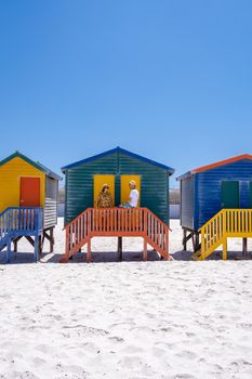 colorful beach house at Muizenberg beach Cape Town, beach huts, Muizenberg, Cape Town, False Bay, South Africa. couple man and woman visiting the beach at Muizenberg