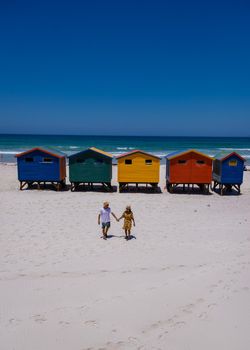 colorful beach house at Muizenberg beach Cape Town, beach huts, Muizenberg, Cape Town, False Bay, South Africa. couple man and woman visiting the beach at Muizenberg