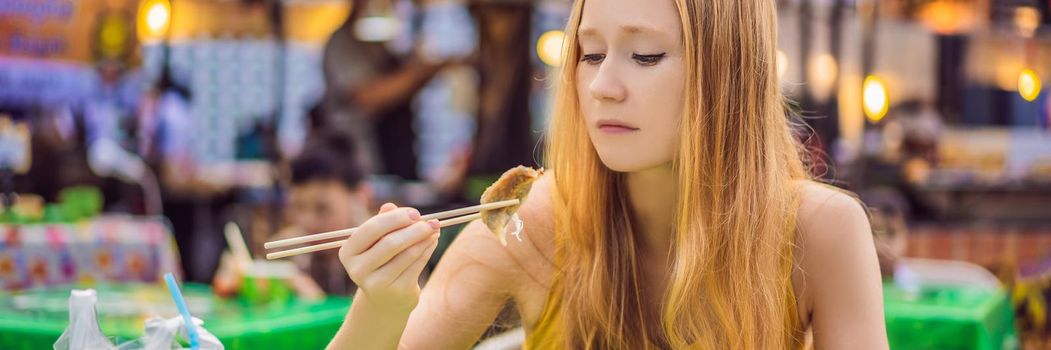 happy cute gilr eating street food and looking enjoyable in a traditional small fair. BANNER, LONG FORMAT