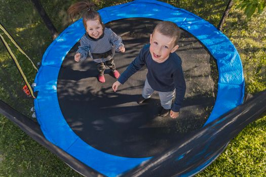 children jumping on a trampoline top view