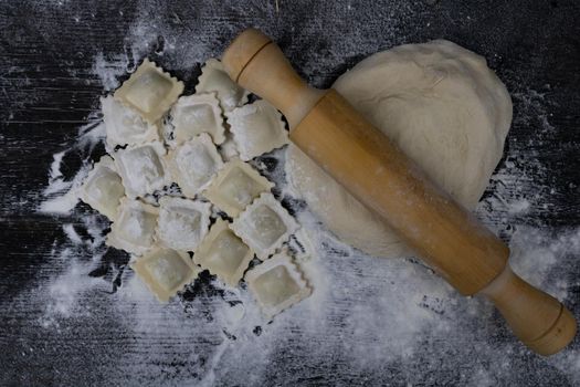 top view rolling pin with dough and ravioli