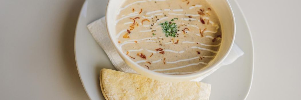 Puree soup with bread on white table. BANNER, LONG FORMAT