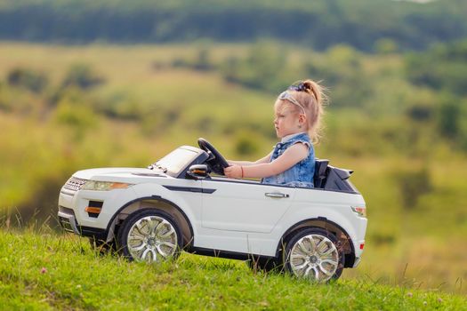 girl riding a white car on the lawn