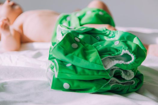 Reusable diaper on the baby copy space . An article about reusable diapers. Saving on diapers. Concern for the environment. Eco-products. Breathable diapers with buttons. High quality photo