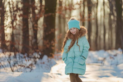 happy girl in turquoise jacket and hat