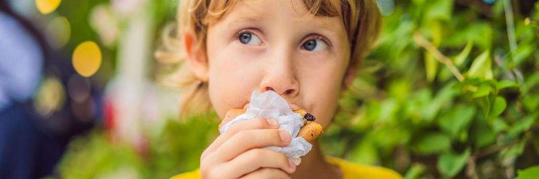 Sweet little caucasian boy, eating pancakes and drinking orange juice. BANNER, LONG FORMAT