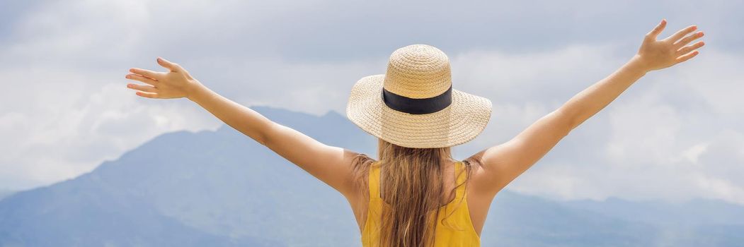 Woman traveler looking at Batur volcano. Indonesia. BANNER, LONG FORMAT