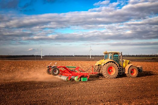 The tractor prepares the ground for sowing and cultivation. Agriculture and agronomy concept.