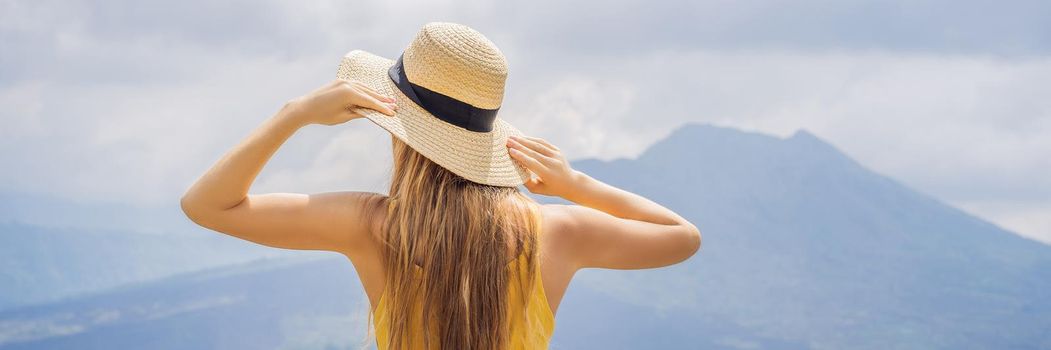 Woman traveler looking at Batur volcano. Indonesia. BANNER, LONG FORMAT