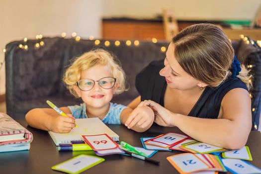 A teacher, a tutor for home schooling and a teacher at the table. Or mom and daughter. Homeschooling.