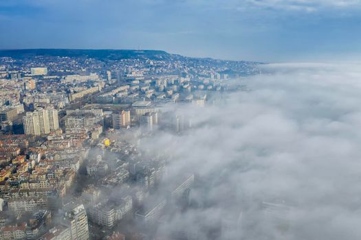 Fog clouds coming over the city from sea, aerial landscape from a drone. View from above. 