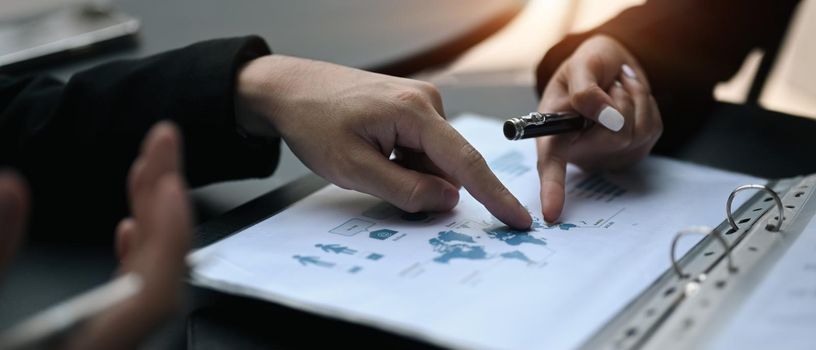 Cropped shot professional businesspeople discussing project strategy while having conversation on financial data report together.