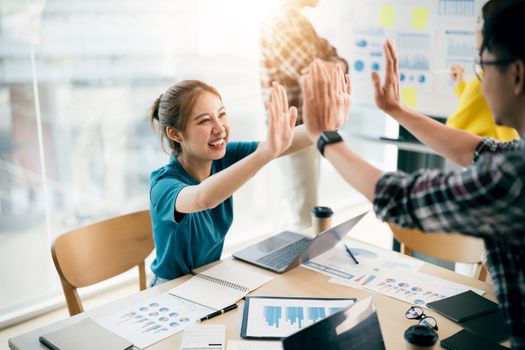 Multiracial young creative people in modern office. Group of young business people are working together with laptop, tablet, notebook. Successful hipster team in coworking. Freelancers.