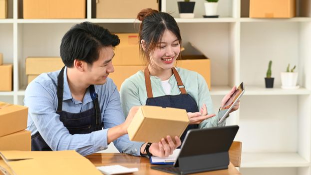 Two business partner preparing parcel boxes of product for delivery to customers. E-commerce, Online selling concept.