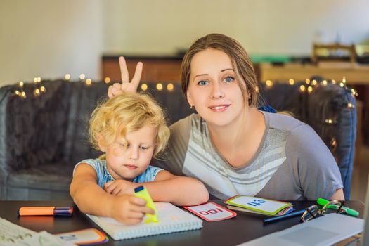 A teacher, a tutor for home schooling and a teacher at the table. Or mom and daughter. Homeschooling.