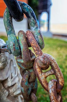 Strong metal rusty metal chain a part of the anchor of the ship. Vertical view