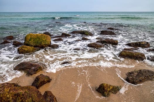 Beauty day view of the sea shore with rocks on the water 