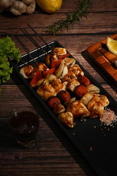 Close up of grilled vegetables and meat on sticks on rustic wooden table. Barbecue, food, party concept.