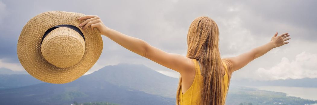 Woman traveler looking at Batur volcano. Indonesia. BANNER, LONG FORMAT