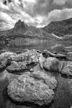 beauty day landscape on the mountain lake with rocks at the front. Vertical view