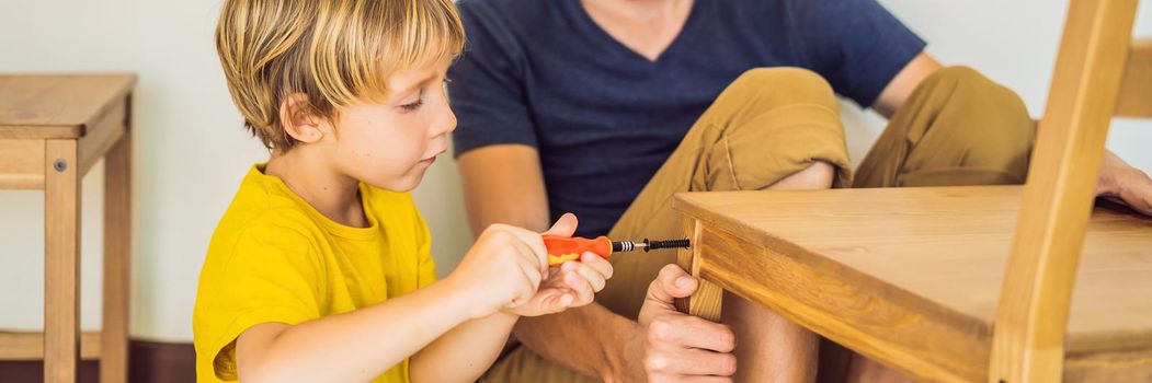 Father and son assembling furniture. Boy helping his dad at home. Happy Family concept. BANNER, LONG FORMAT