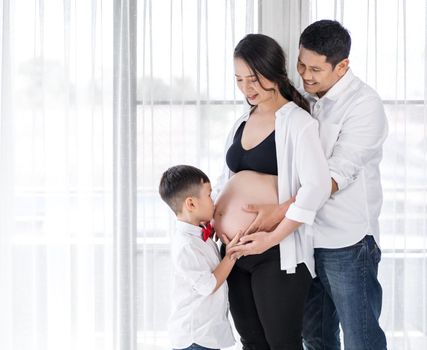 happy family concept, pregnant mother, father and son kissing