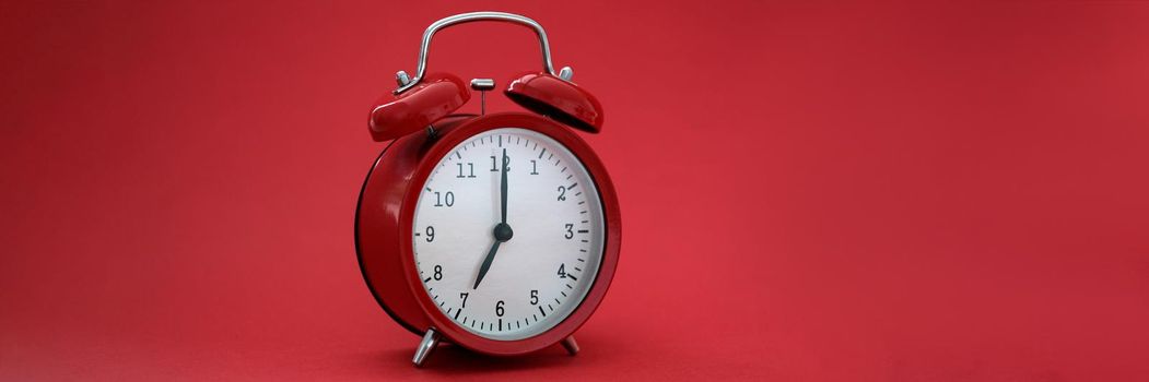 Vintage stylish alarm clock with bells on a red background, close-up. Planning and deadline. Productivity of the day